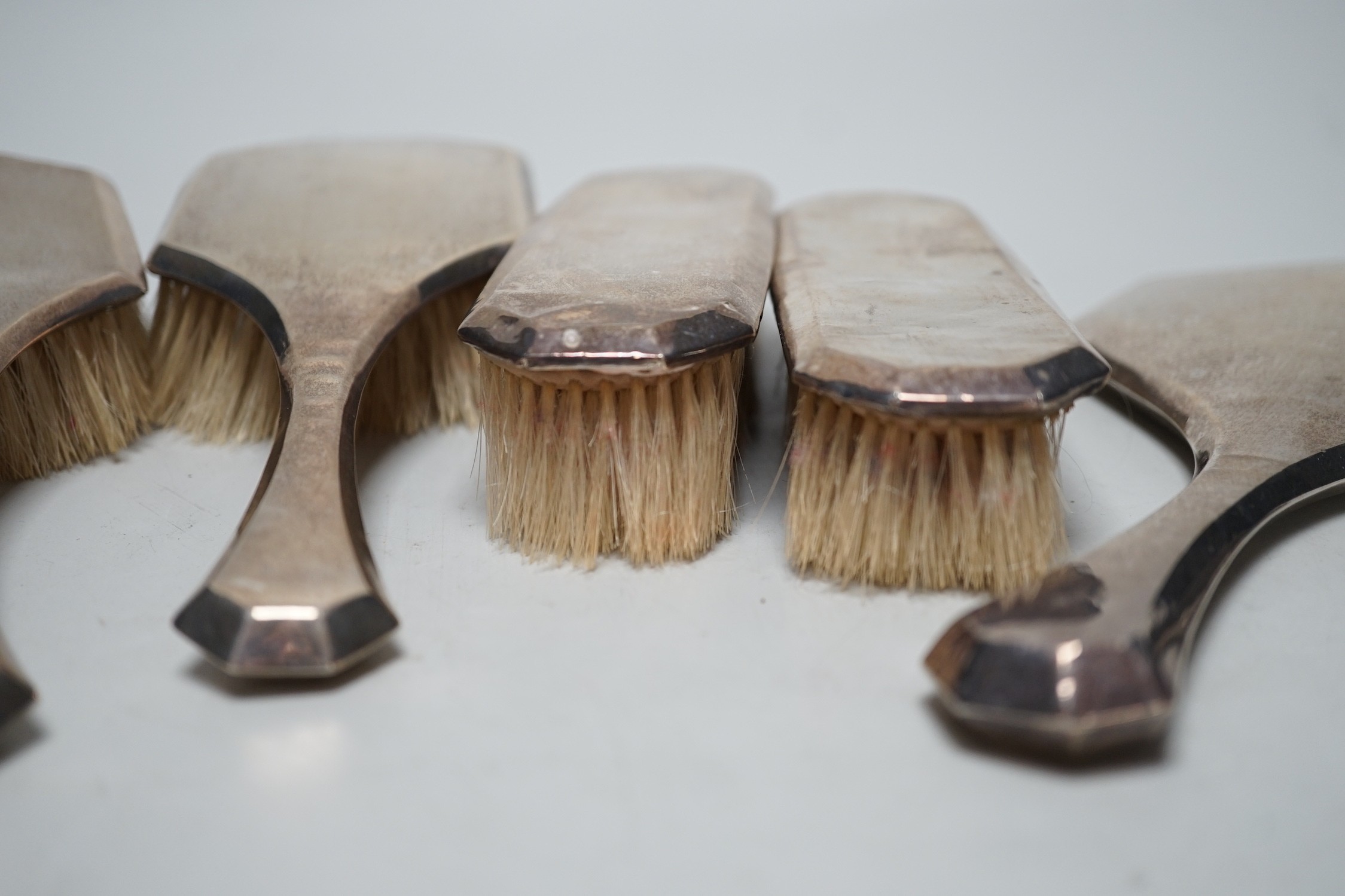 A 1920's silver mounted five piece mirror and brush set.